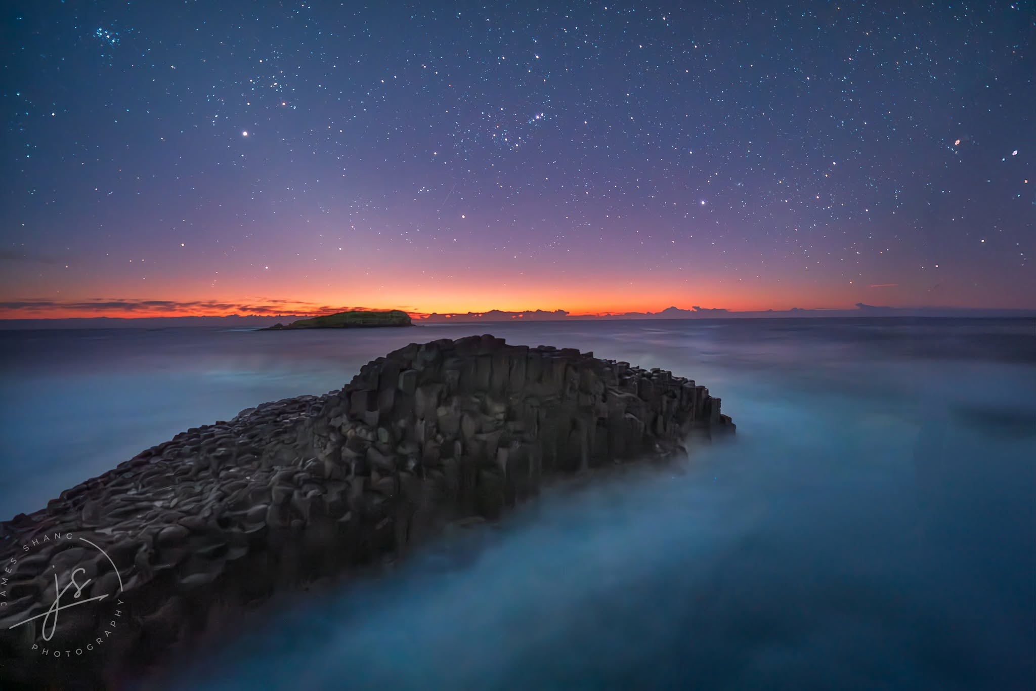 Fingal Head basalt columns beneath a star-filled sky before dawn