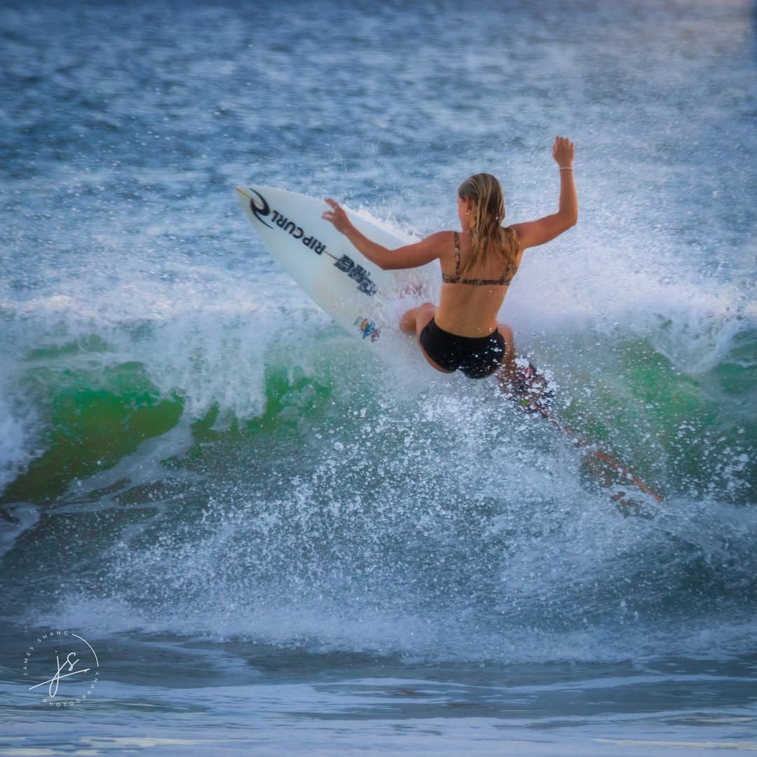 Surfer carving through a breaking wave